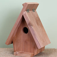 Triangular bird house shape. Large roof lifts on the one side. Red cedar wood constuction.