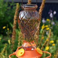 Orange glass bottle with diamond shape. Orange poly base with yellow flower feeding ports. 