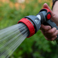 Water nozzle spraying water onto a garden, it is attached to a hose.