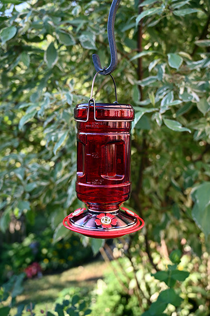 Red water cooler glass shape. Red and copper coloured base with red flower shaped feeding holes.