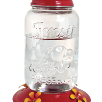 Shaped like a mason jar. Red lid and base with yellow flower shaped feeding holes.