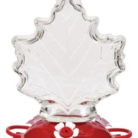 Maple leaf shaped glass, red circular base with white flower shaped feeding holes.