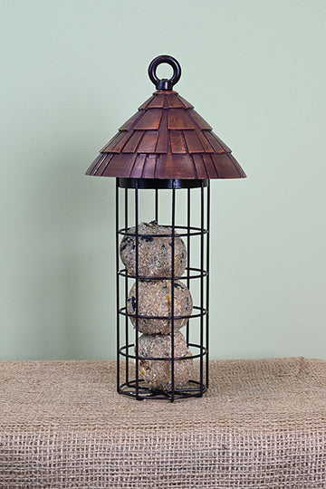 Cylinder black cage holding 3 suet balls with a round shingle styled roof.