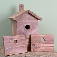 Red cedar wood construction. Rectangular shaped house. 3 pieces of wood, each with a different hole size.