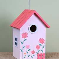 Pink birdhouse with 4 pink flowers and 1 small orange flower.