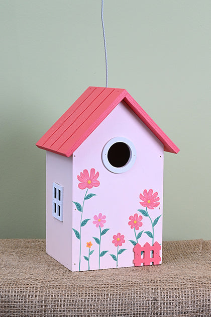 Pink birdhouse with 4 pink flowers and 1 small orange flower.