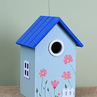 Blue birdhouse with pink flowers.