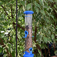 Hanging outdoors on a pole system. Clear tube with blue lid, perches, and base.