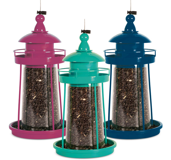 Lighthouse style feeders filled with seeds. Purple on the left, turquoise in the middle, dark blue on the right.