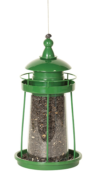 Green lighthouse shaped feeder filled with seeds.