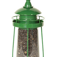 Green lighthouse shaped feeder filled with seeds.
