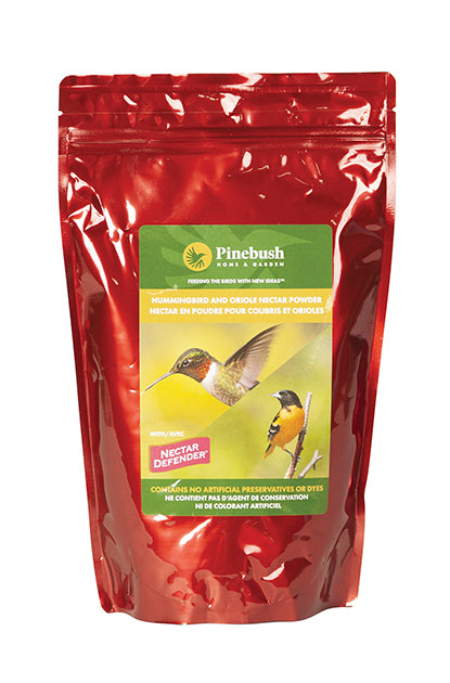Red rectangle packaging holds the nectar powder. Green label with the Pinebush logo and a photo of a hummingbird and oriole on it.