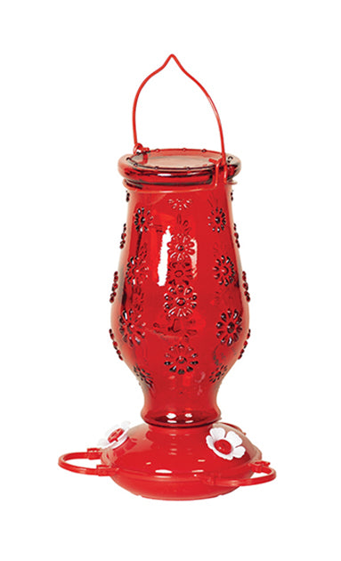 Red floral glass, red circular base with white flower shaped feeding holes.