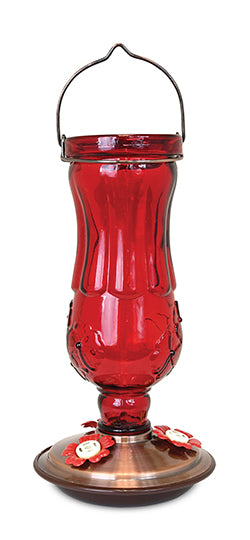 Red glass with flower details. Copper coloured base with red flower shaped feeding holes.