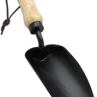 Wooden beige handle, strap around the handle, black trowel.